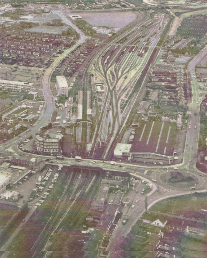 In this view from 1973 much can be seen. The main rail line cuts through the picture with the West Yard sidings, to the left is Rowland Road roundabout and below that is the land where The New Life Church was built. Above the roundabout is the former Co-op warehouse/distribution centre which burned down in the 1990s. On the left is the open space where the Model traffic area stood and top right is the former Station Road playing fields.