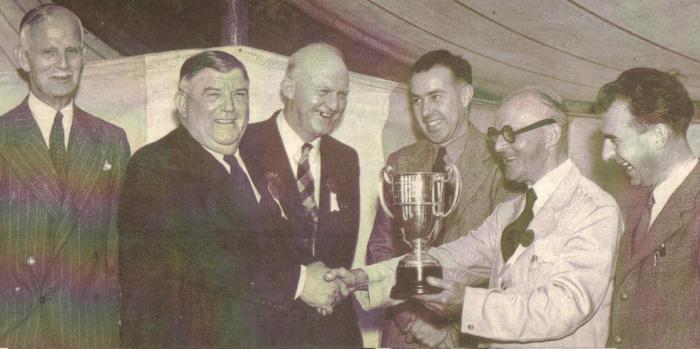 Herbert Kirman (in white) receives the Hunting Cup from Lord Quibell for the best display stand at the Scunthorpe Agricultural Show c.1950. Left to right is Fredrick Gough (former Grammar School Head). Lord Quibell, president of the society, A McIntyre, head of the society, Leslie Hather, Director of Kirman's, Herbert Kirman and Tom Pollock, Director of Kirman's